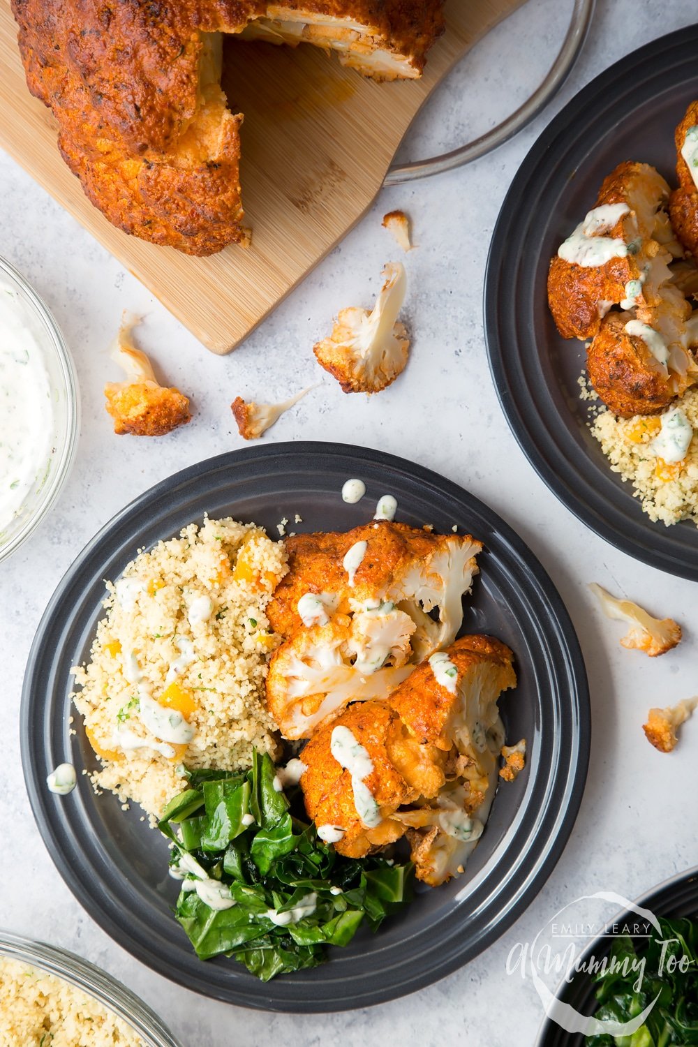 Harissa roasted cauliflower served with wilted spring greens and herby couscous, drizzled with lemon tahini sauce