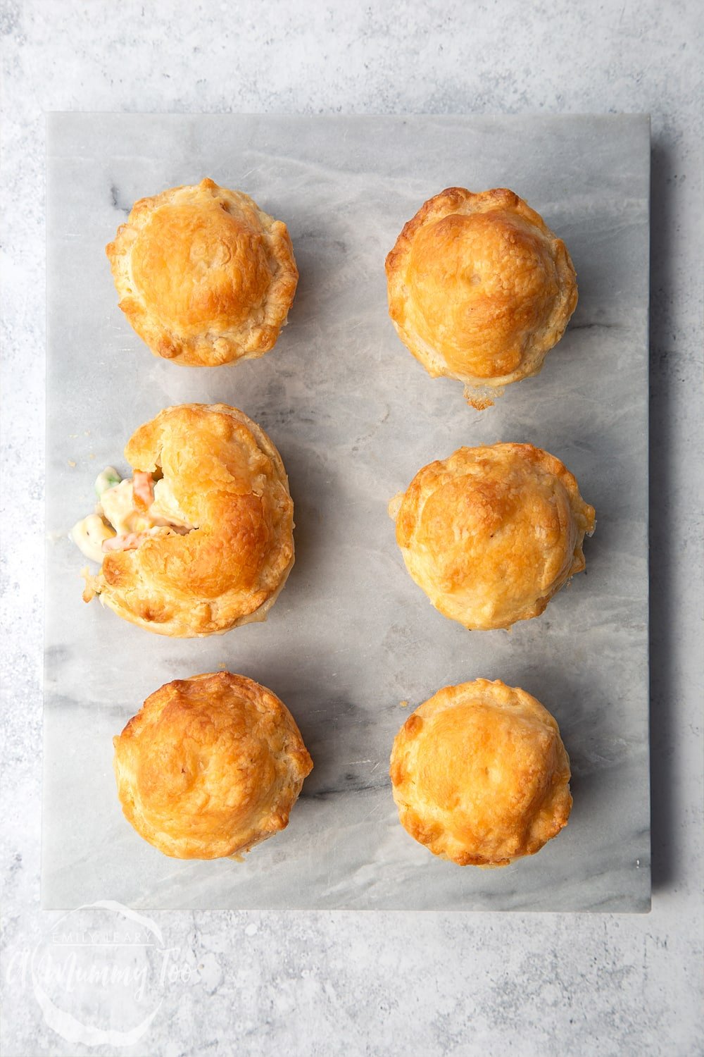 Creamy tofu and vegetable vegan mini pies served on a marble board