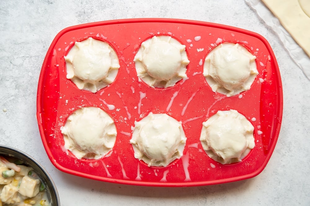 Brush the tops of the creamy tofu and vegetable vegan mini pies with milk before baking