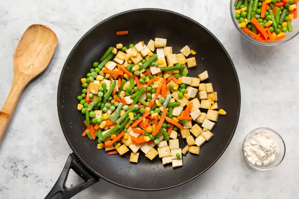 Add the frozen vegetables to the tofu and fry