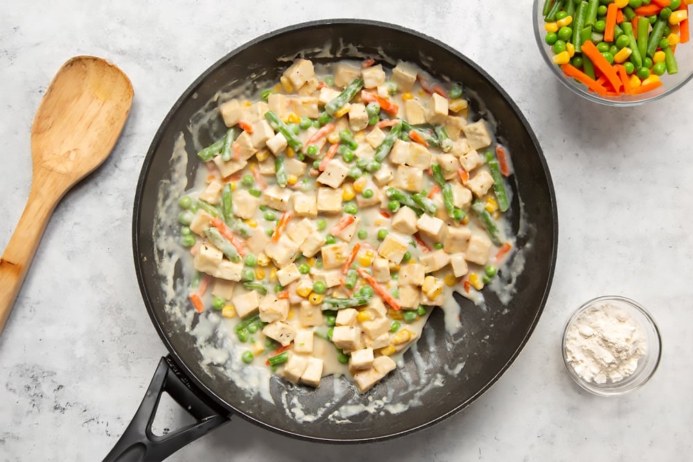 Preparing the creamy tofu and vegetable pie filling in a frying pan