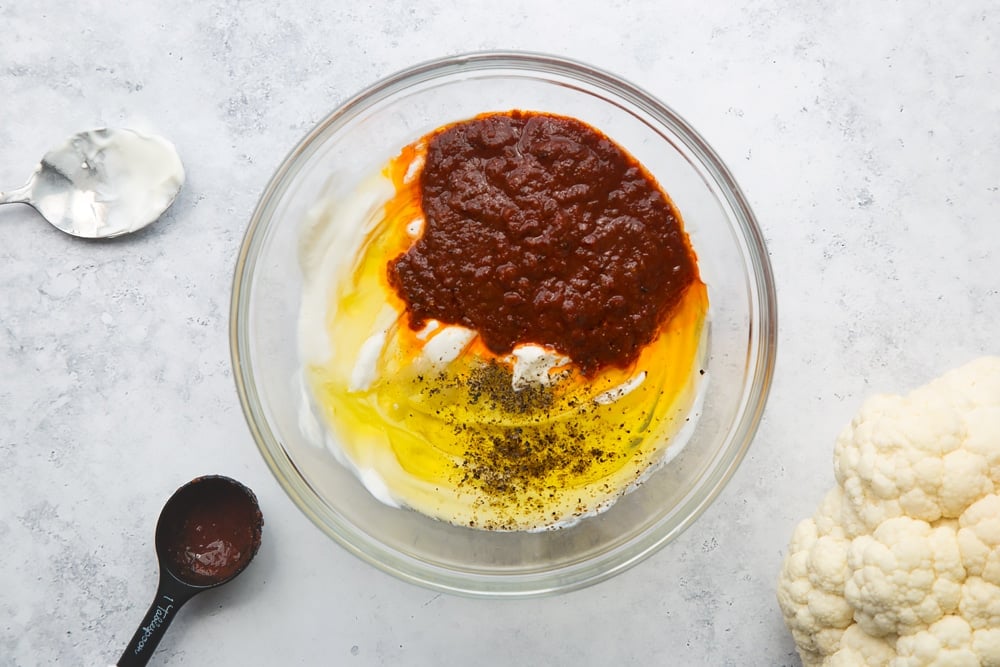 Harissa, yoghurt, oil, salt and pepper in a bowl