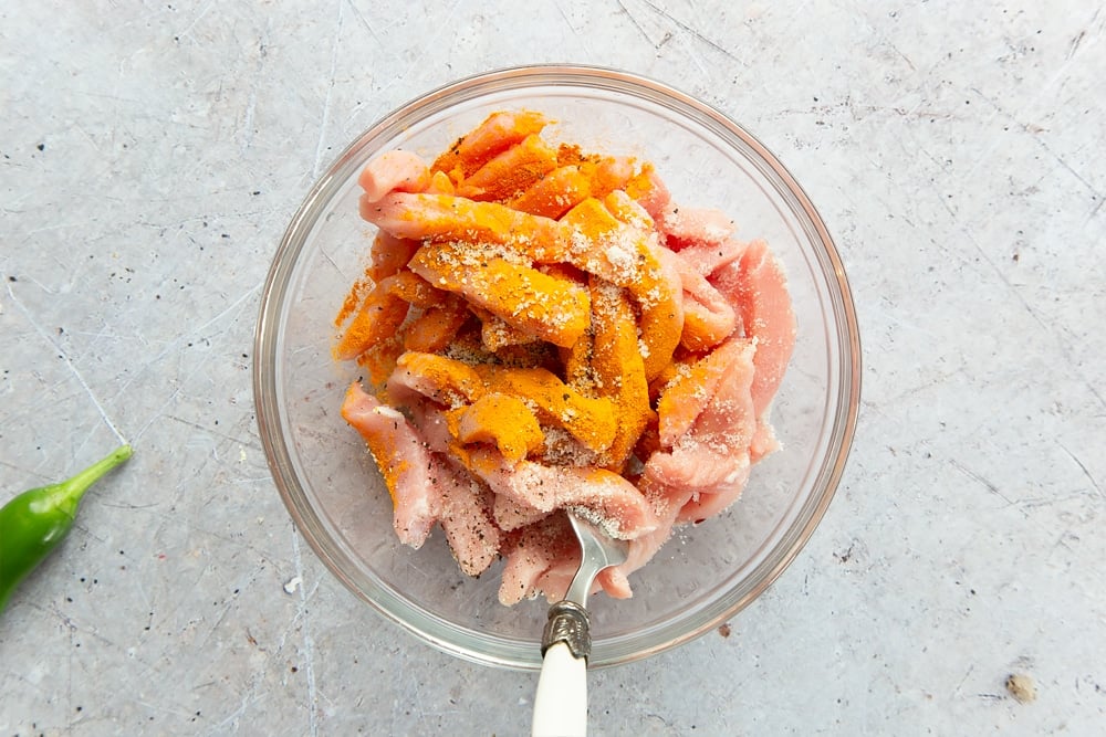 Seasoning the pork with turmeric, salt and pepper