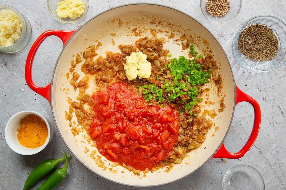 Tinned tomatoes, green chilli, grated ginger added into the pan with the onions