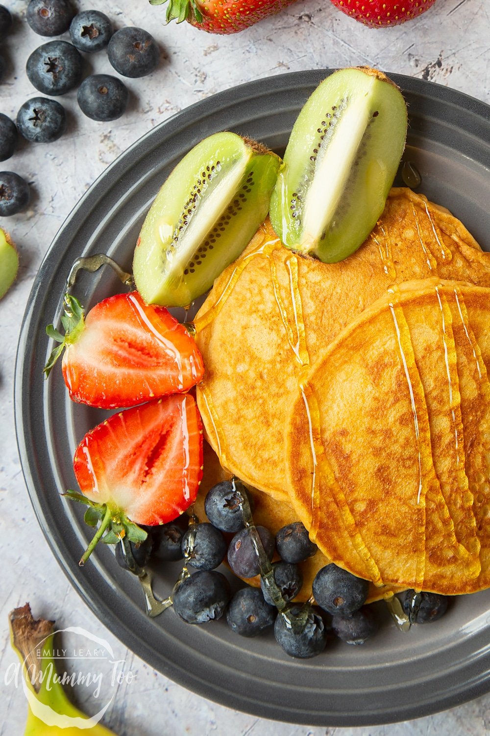 A stack of sweet potato pancakes served with strawberries, kiwi and blueberries