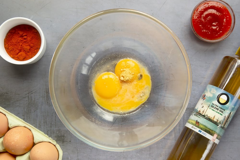 Mixing egg yolks, vinegar and mustard to make the sauce