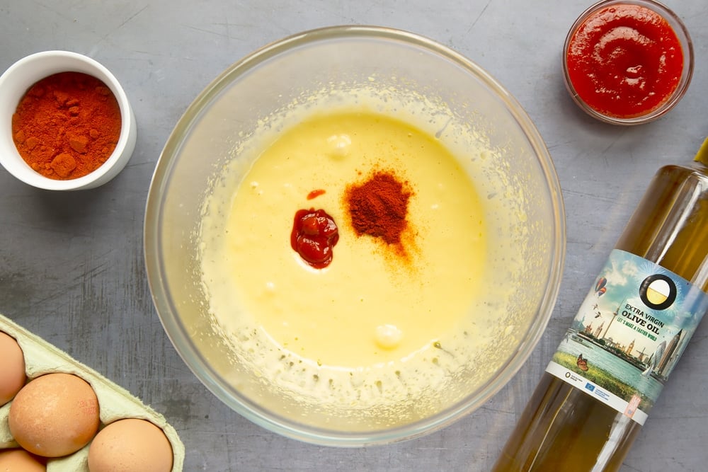 Adding paprika and sriracha to the spicy Spanish potatoes sauce