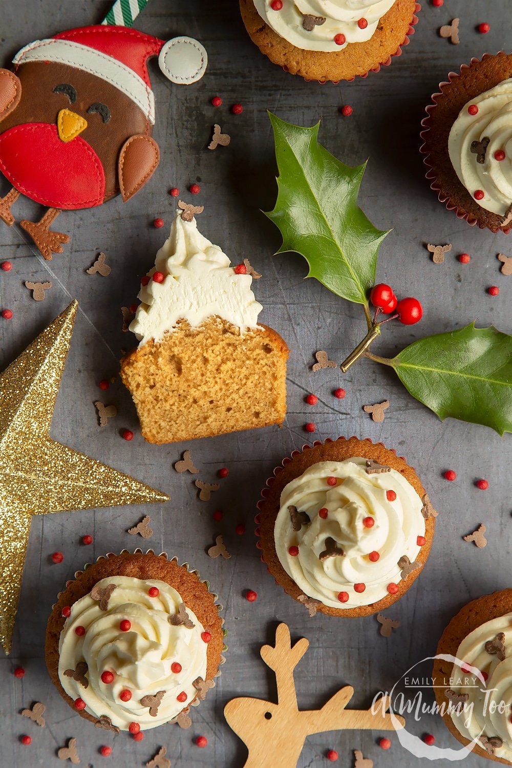 overhead shot of multiple spiced Christmas cupcakes with marzipan frosting on a grey table. 