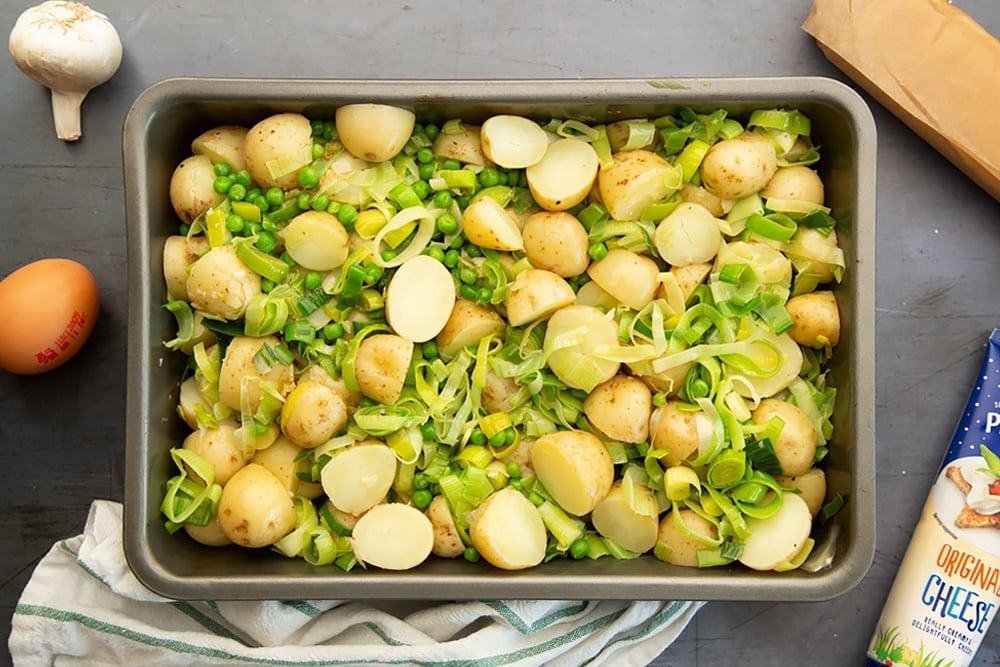 Potatoes, leeks and garlic in a roasting tray