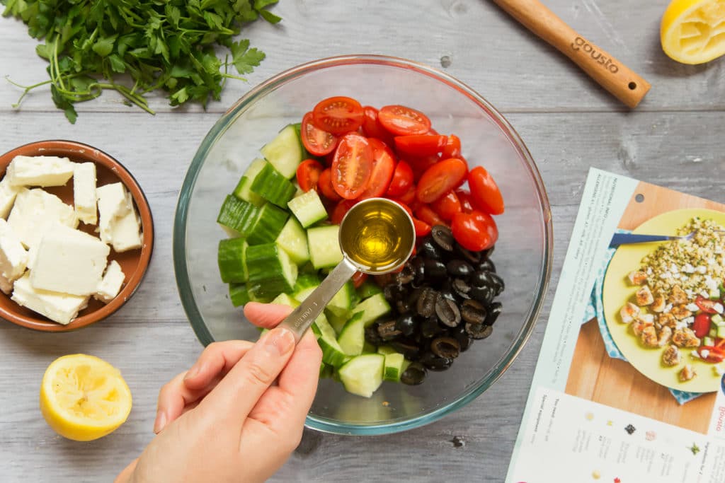 Adding olive oil to the salad