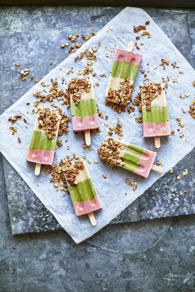 Overhead shot of Fruit and Vegetable Lollies topped with granola served on a marble plate