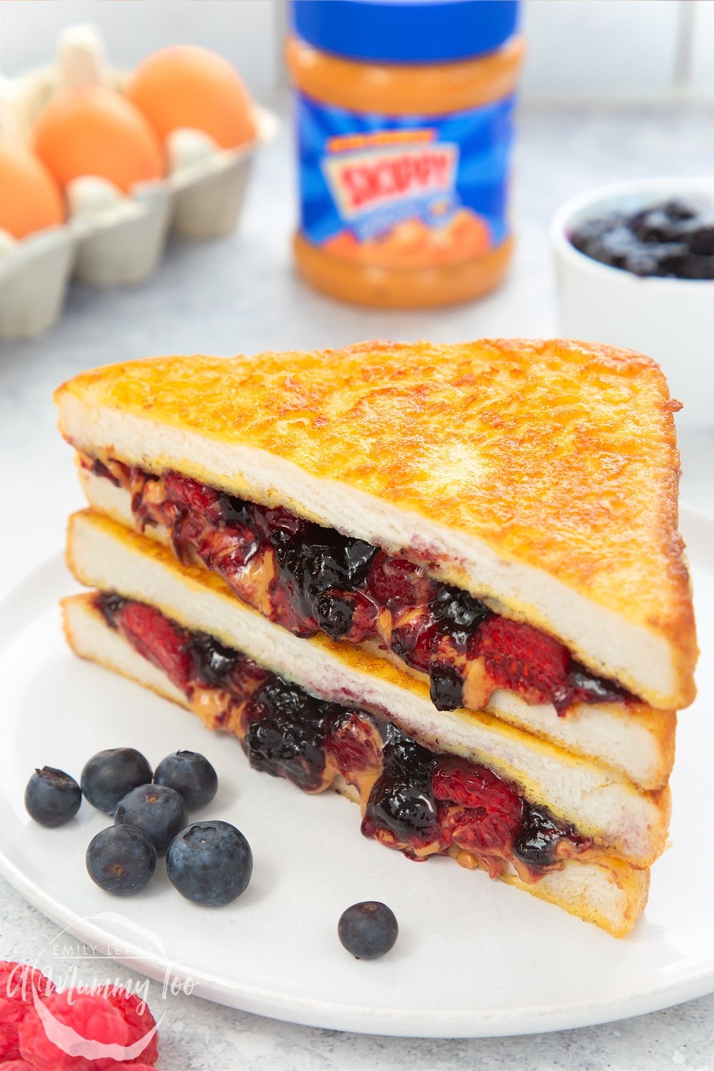 French Toast peanut butter and jelly sandwich, shown stacked with blueberries