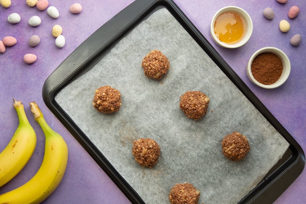 Cake mixture divided into balls, shown on a baking tray