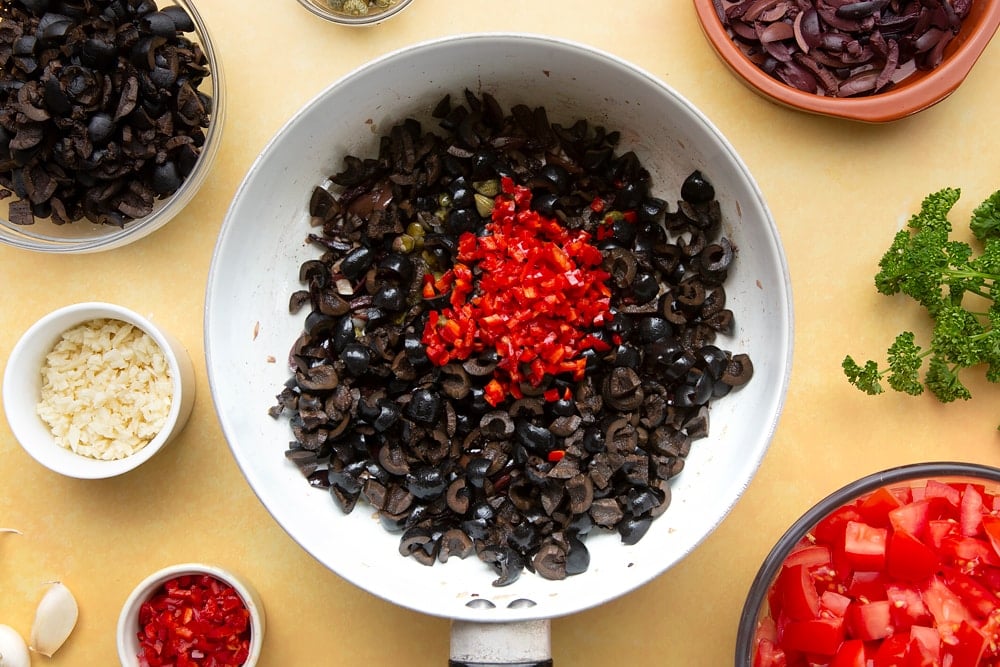 spaghetti alla puttanesca pan contents with crushed chillis