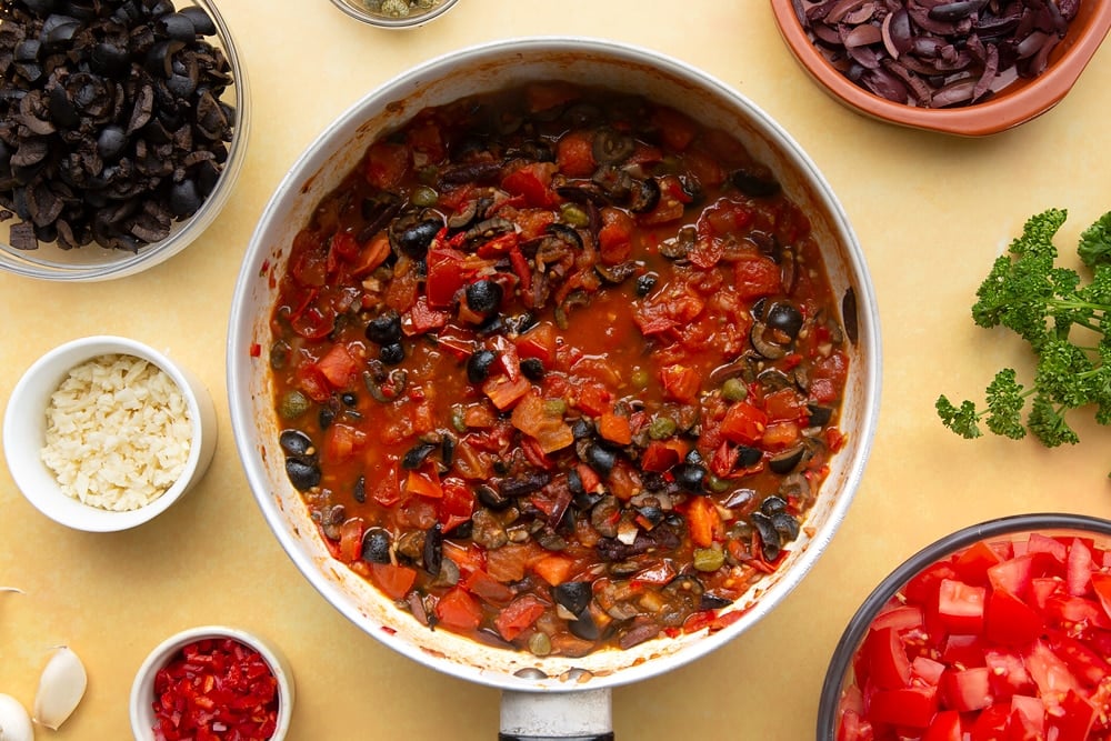 spaghetti alla puttanesca ingredients having bean cooked and simmered 