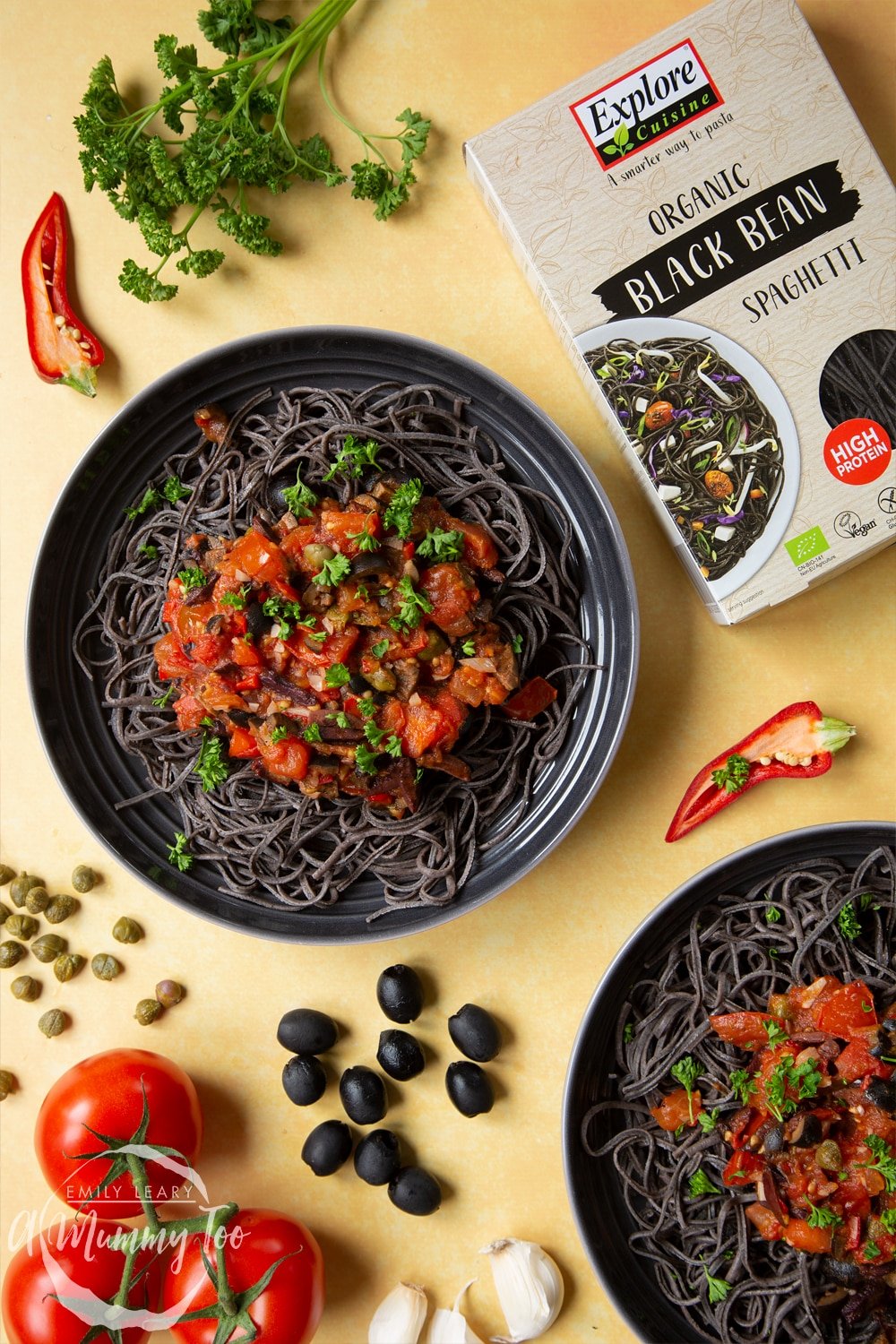 Two bowls of spaghetti alla puttanesca made with Explore Cuisine's Organic Black Bean Spaghetti