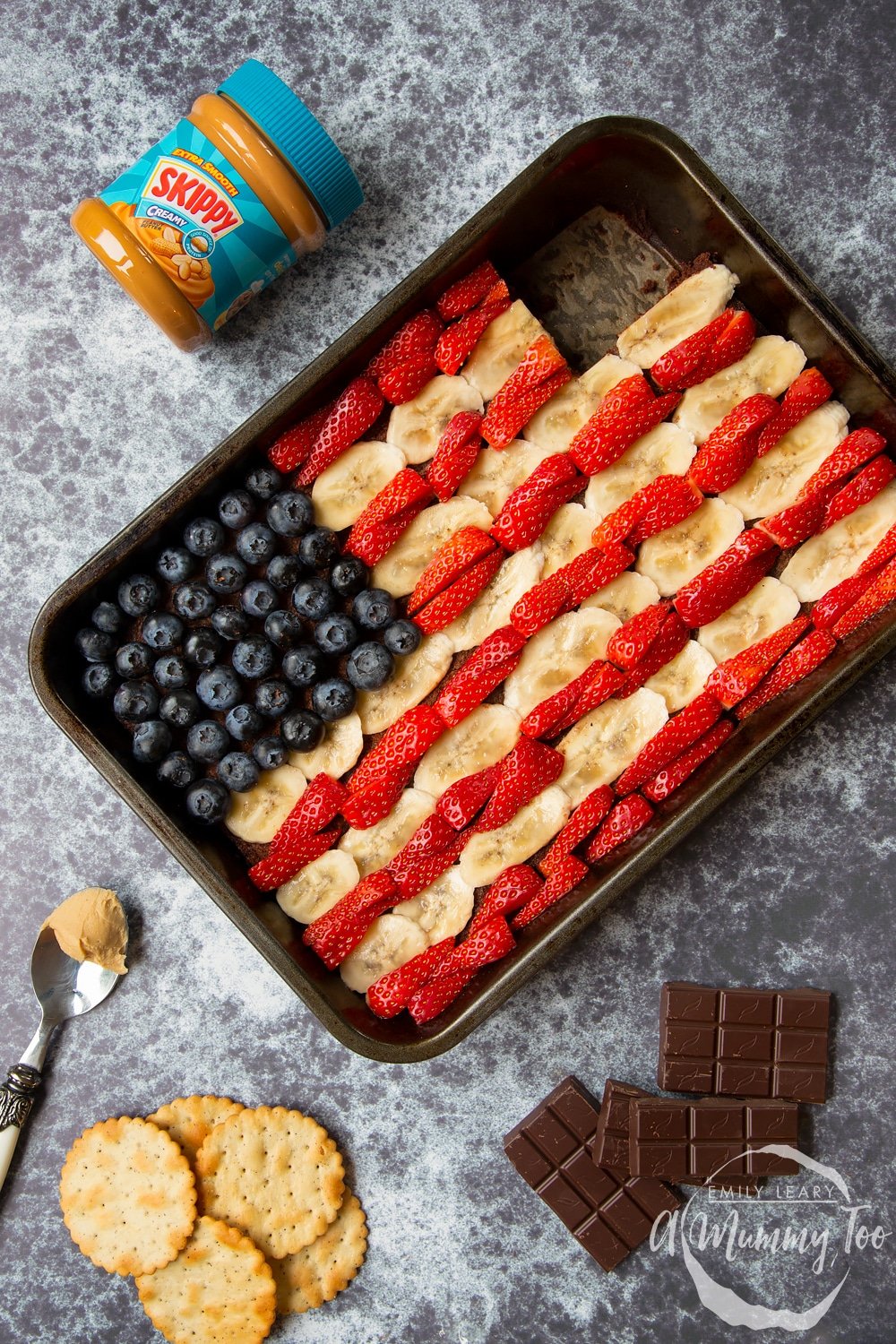 The decorated peanut butter brownies sheet pan with bananas strawberries and blueberries