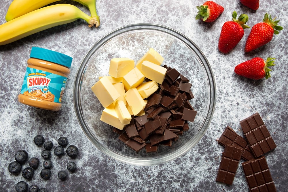 We start making the peanut butter brownies by microwaving a bowl of chocolate and butter