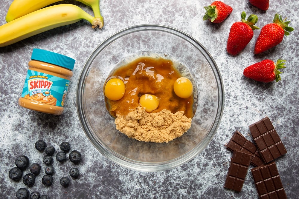 A seperate bowl to the earlier bowl with the peanut butter brownies cake mixture we habe some eggs and brown sugar ready to be mixed together.