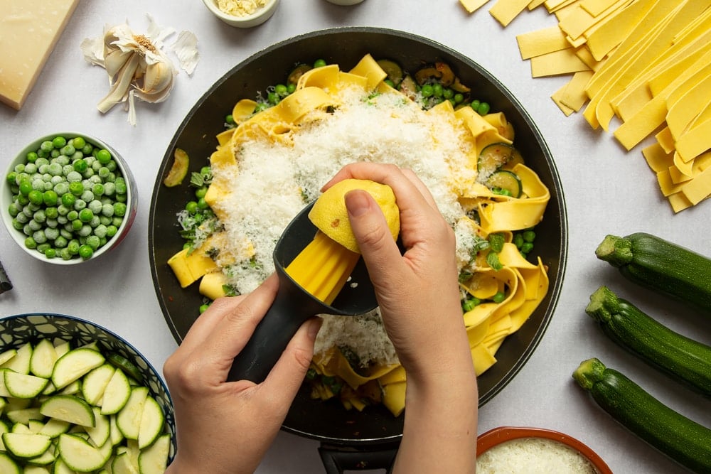 Courgettes, peas, fresh mint, Parmesan and lasagne pasta strips stirred together in a frying pan. Lemon juice added.
