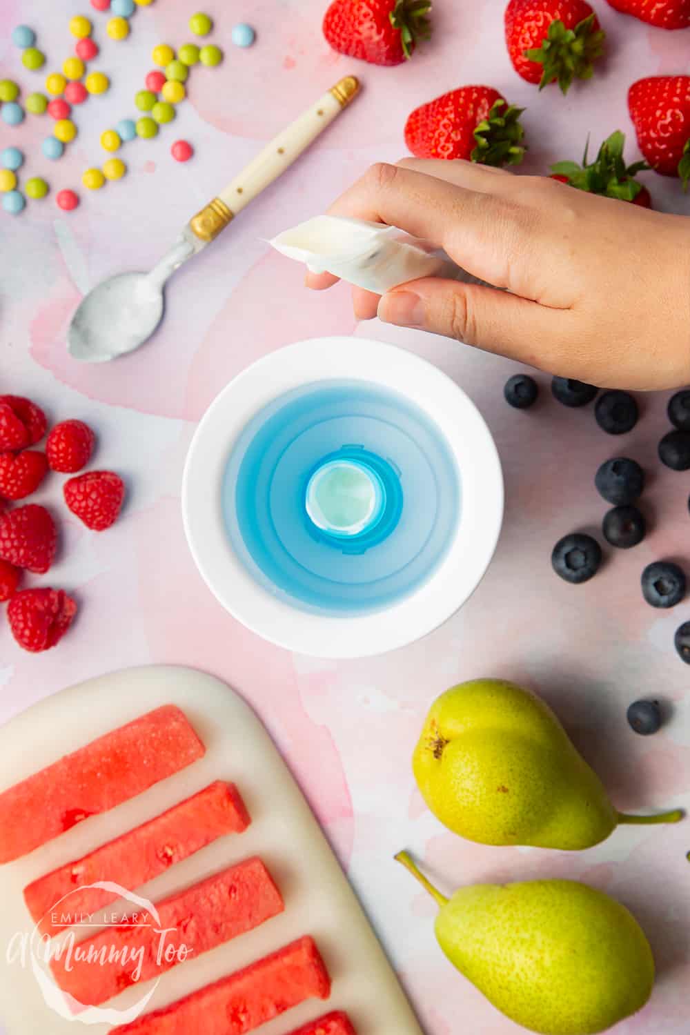 YoPop frozen yogurt maker with a clear yogurt pop bag on the top held by a hand.