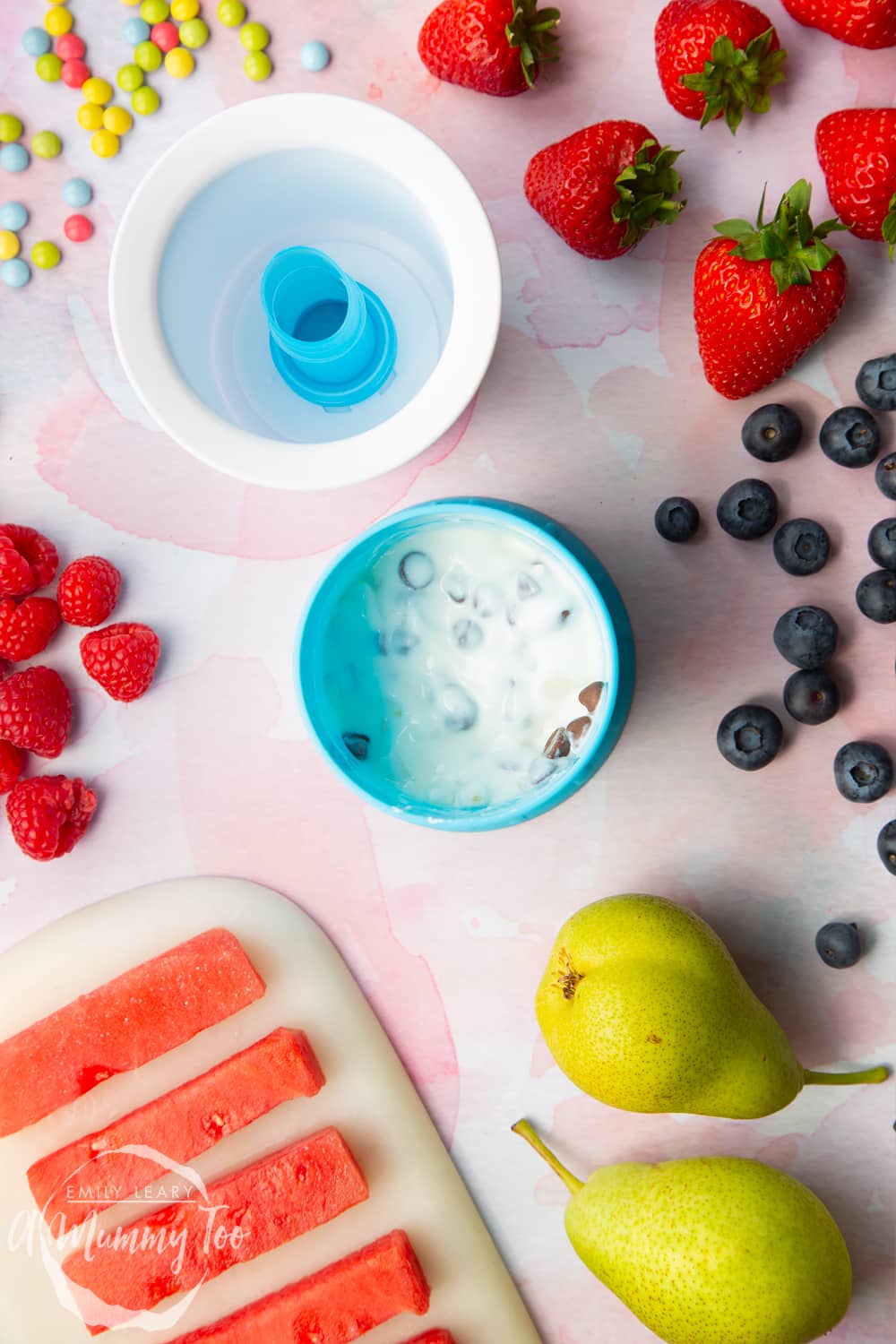 YoPop frozen yogurt maker open with yogurt, pear and chocolate mixed toghether in a blue bowl.