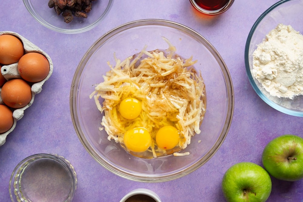 No junk apple and strawberry muffins - grated apple, eggs, maple syrup and oil in a bowl.