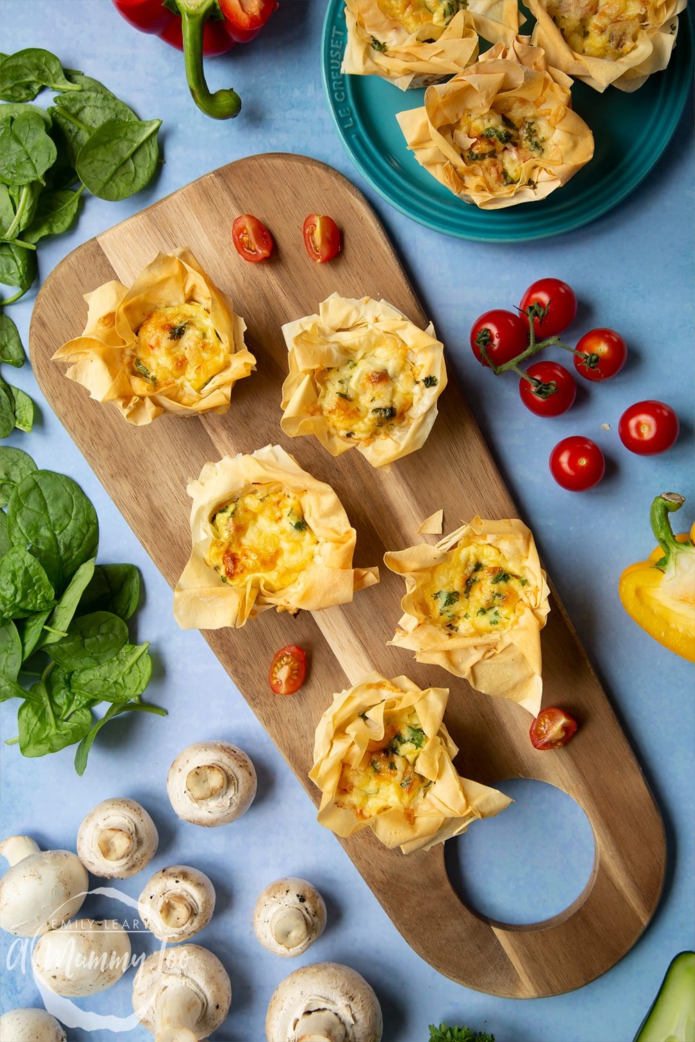 Filo pastry mini quiches recipe. Quiches arranged on a board surrounded by salad.