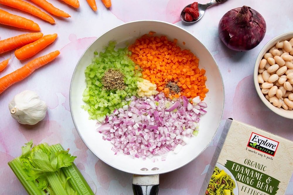 Raw carrots, celery, onion, garlic finely chopped in a frying pan along with oregano, salt and pepper.