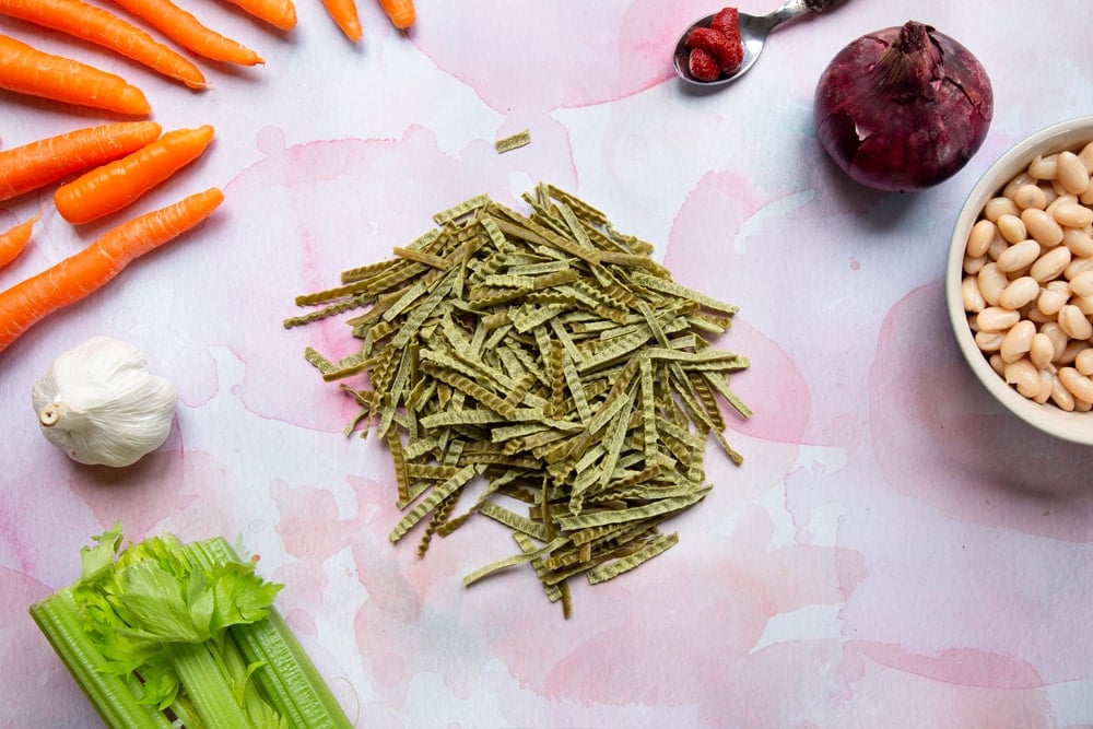 Explore Cuisine Organic Edamame & Mung Bean Fettuccine laid out on a table, snapped into pieces a couple of inches long.