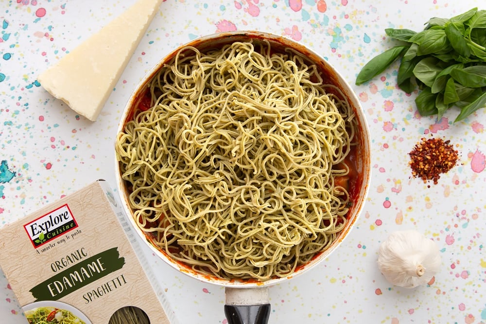 spaghetti alla norma ingredients together in a pan, with the spaghetti on top ready to be mixed 