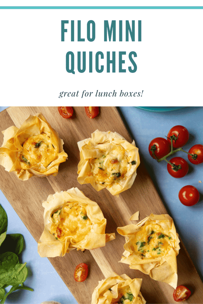 Overhead shot of Filo Pastry Mini Quiches on a wooden board. At the side there's some cherry tomatoes on a blue background. At the top of the image there's some text describing the image for Pinterest. 