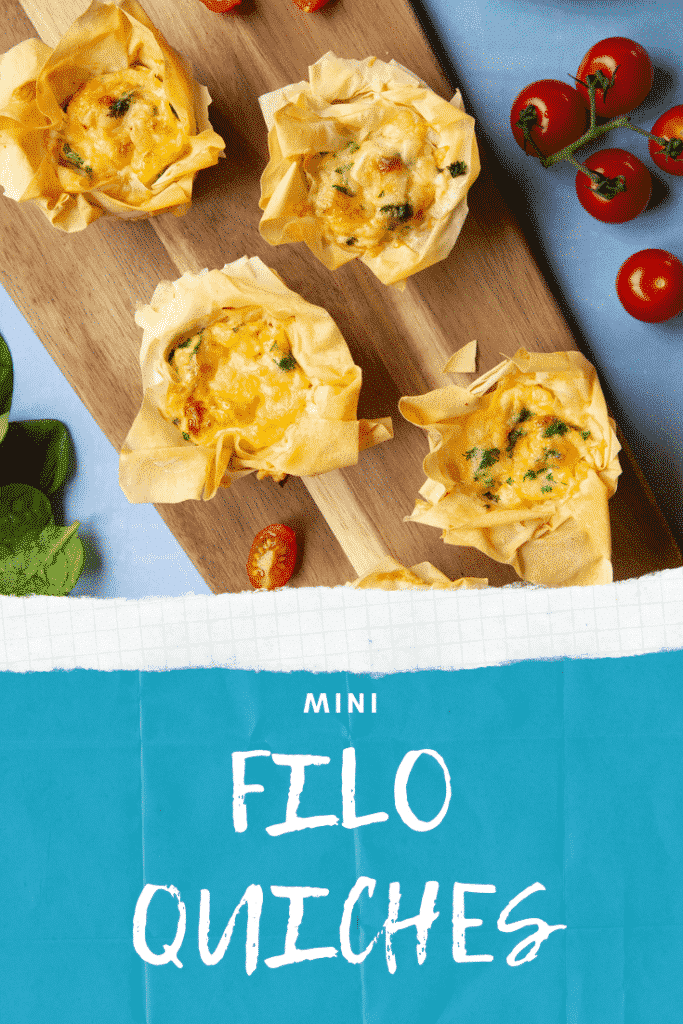 Overhead shot of the Filo Pastry Mini Quiches on a wooden board on a blue background. At the bottom of the image there's some text describing the image for Pinterest.