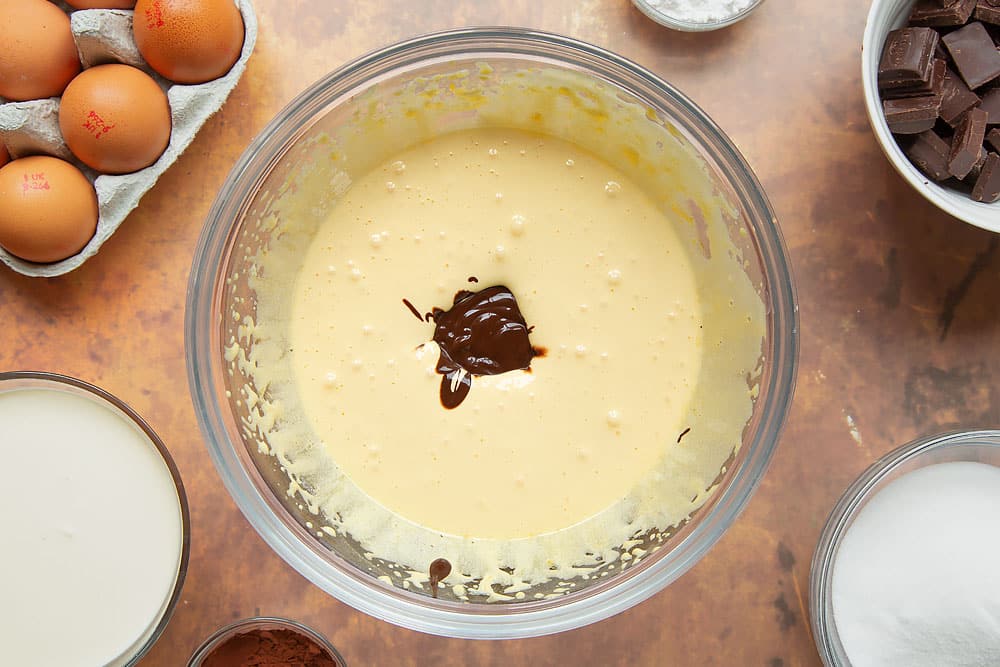 Melted dark chocolate added to egg yolks and caster sugar in a mixing bowl, beaten to ribbon stage.