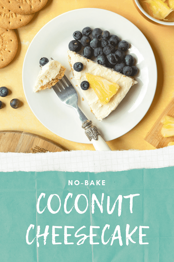 Coconut cheesecake decorated with fruit and served as a slice on a plate, with a piece on a fork