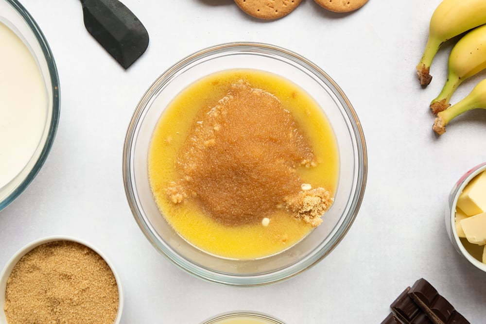 Crumbled biscuit in bowl with butter and sugar