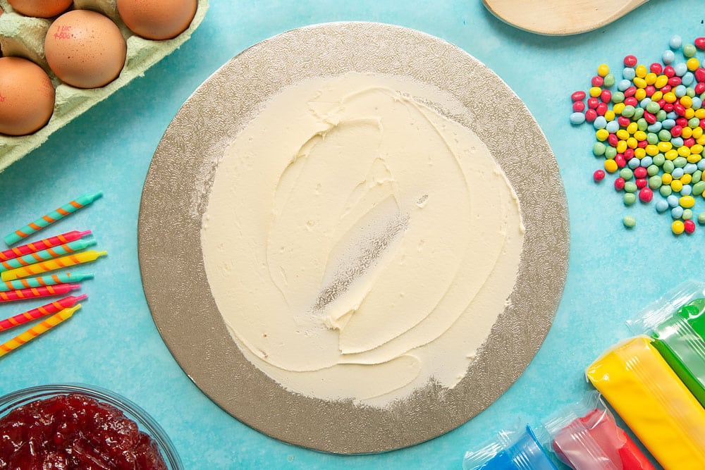 Vanilla buttercream spread on the base of a cake board