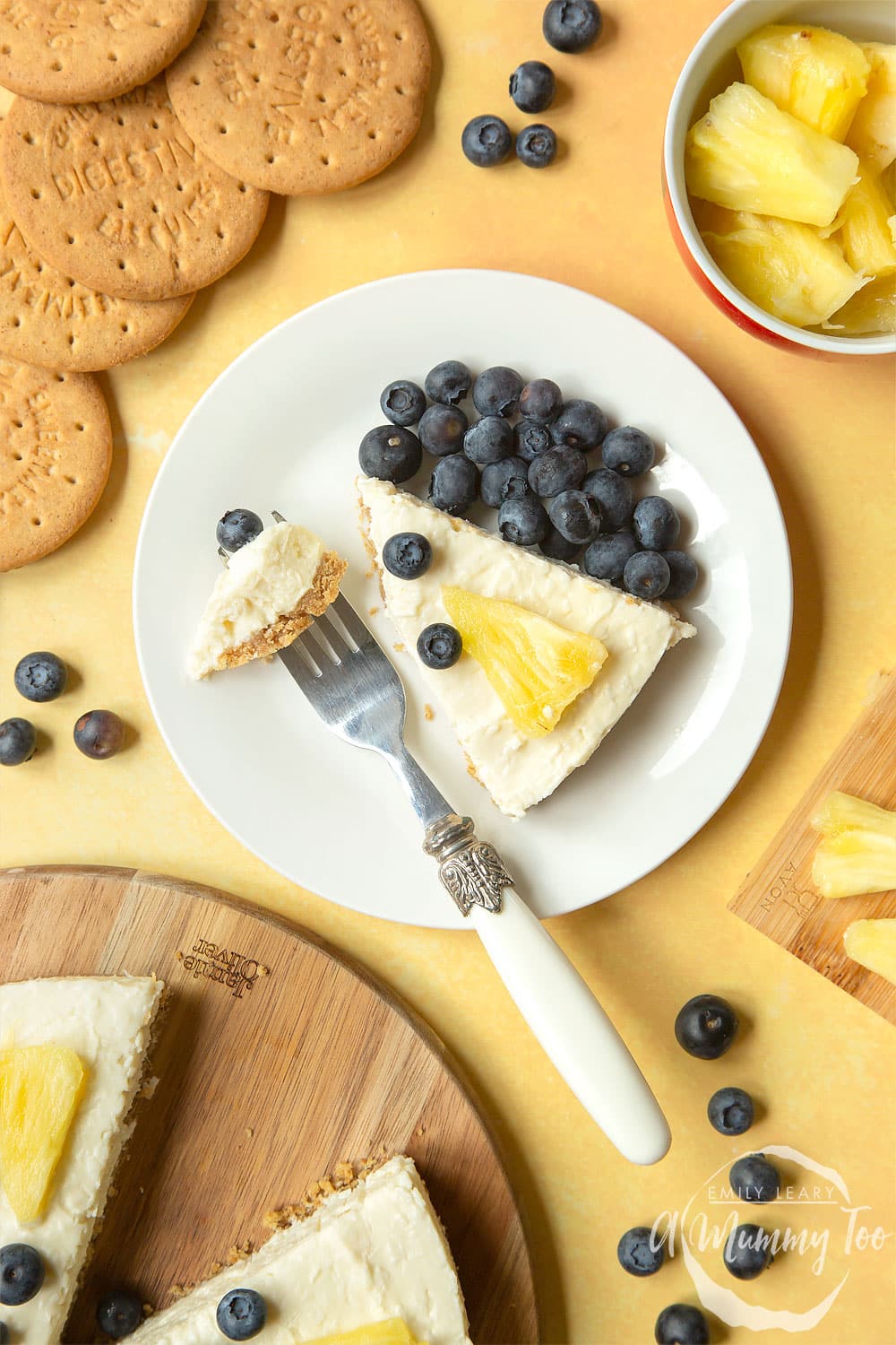 Slice of extra special no-bake coconut cheesecake on a small plate with blueberries and a fork.