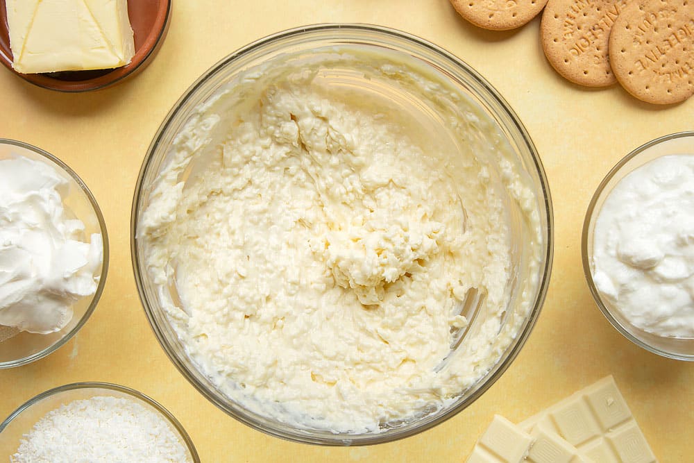 Cream cheese, yogurt, desiccated coconut and melted white chocolate combined in a large mixing bowl. 