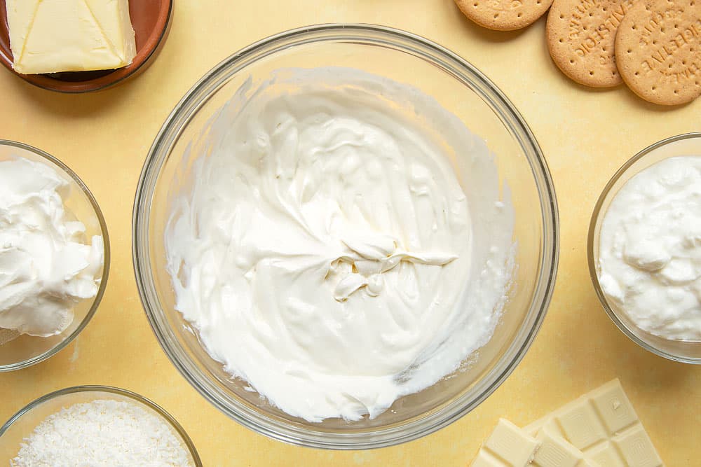 Cream cheese and yogurt whisked together in a large mixing bowl.