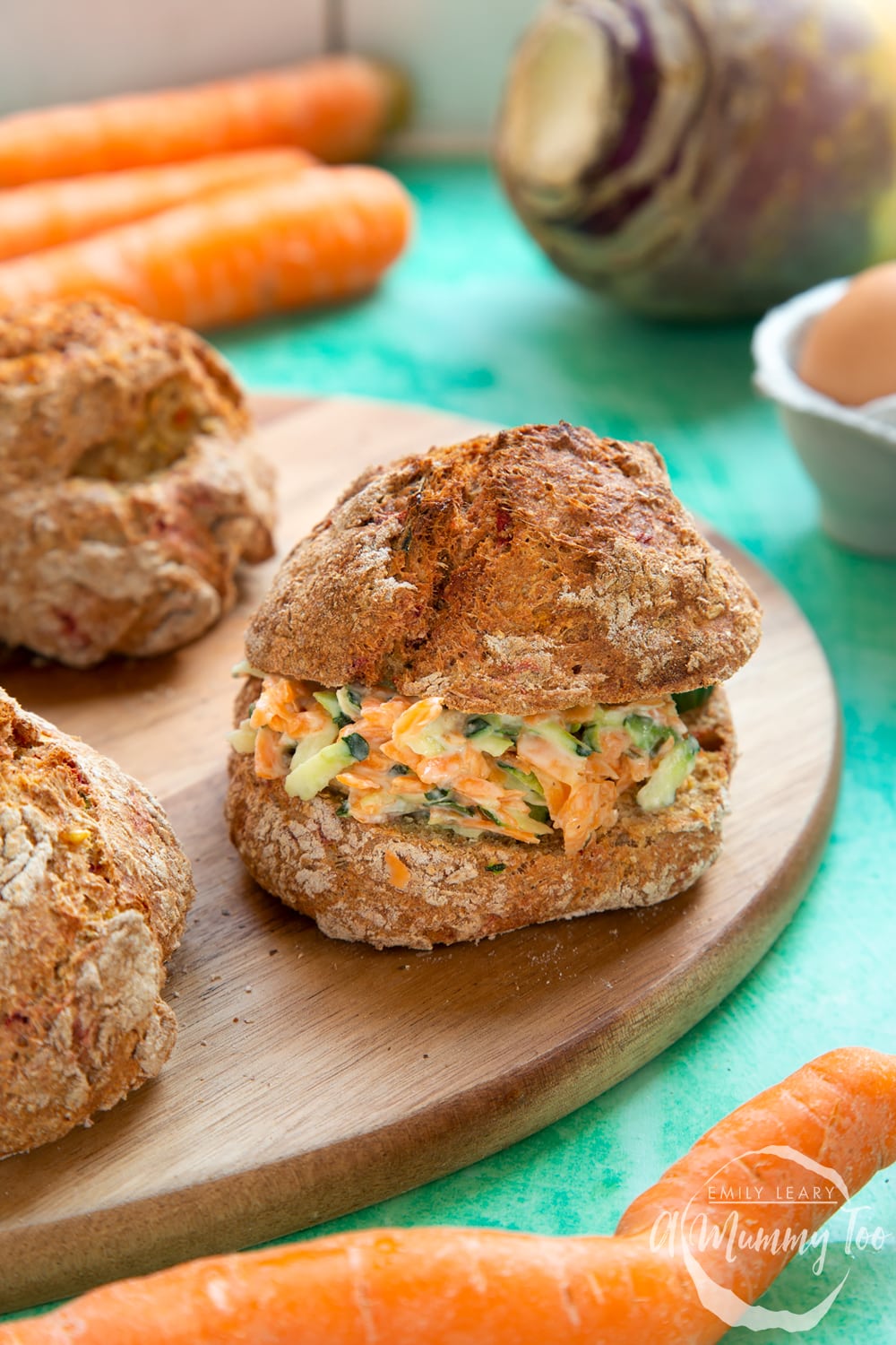 Vegetable soda bread rolls recipe - rolls arranged on a board, one roll in focus filled with grated vegetables and cream cheese.