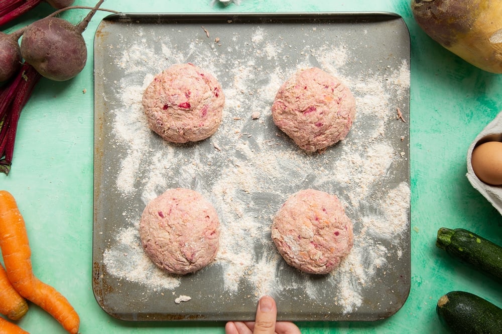 Vegetable soda bread rolls recipe - balls of pink dough placed on a floured baking tray. 