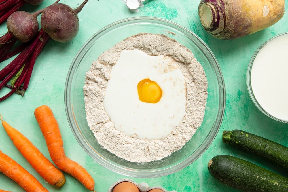 Vegetable soda bread rolls recipe - a bowl with wholemeal flour and baking powder, buttermilk and egg.