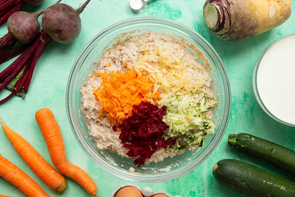 Vegetable soda bread rolls recipe - a bowl with dough and grated vegetables on top. 