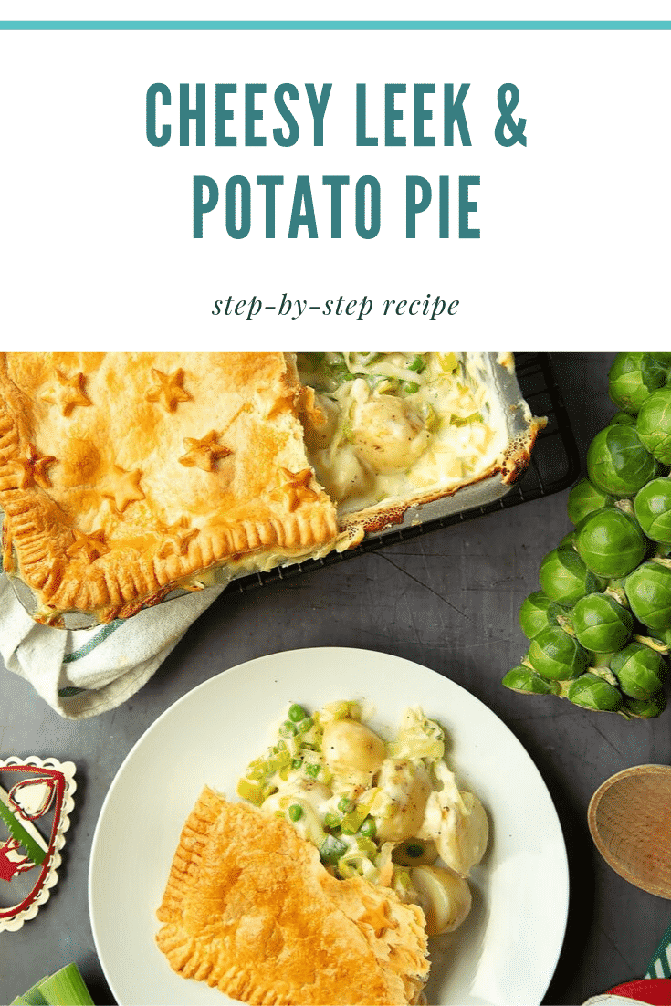 Overhead shot of a plate of cheesy leek and potato pie next to some of the ingredients required to make the recipe. At the top of the image there is some teal text describing the image for Pinterest. 