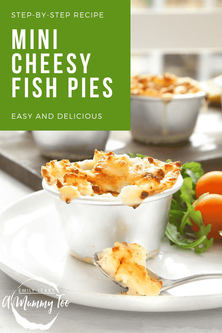 A close up shot of a mini cheesy fish pie on a white plate with a side salad. In the background you can see some additional fish pies on a wooden board. In the top left hand corner there's some white text on a green background describing the image for Pinterest.