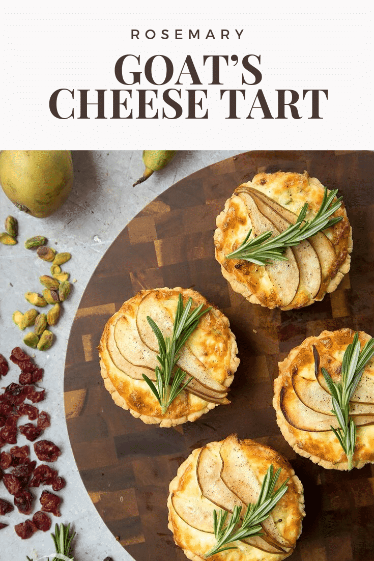 Overhead shot of four rosemary goat's cheese tarts on a wooden board with some of the ingredients required to make the dish on the side. At the top of the image there's some text describing the image for Pinterest. 