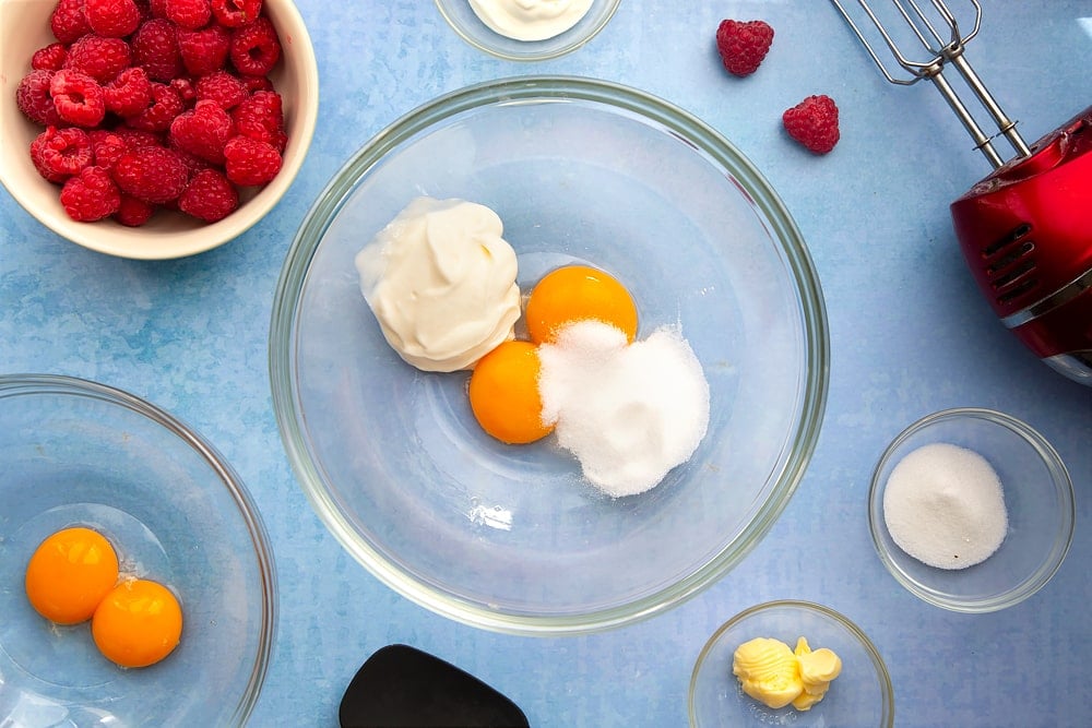 Mixing bowl containing egg yolks, yogurt and sugar