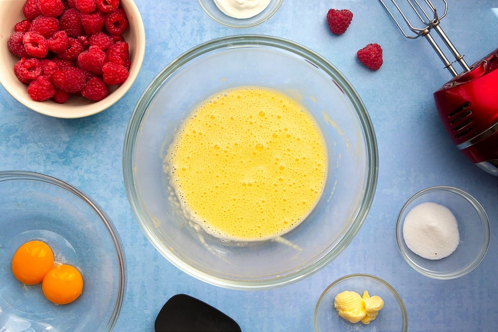 Mixing bowl containing egg yolks, yogurt and sugar, beaten together