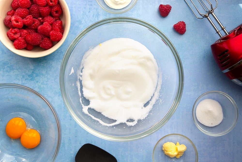 Mixing bowl containing egg whites beaten to stiff peaks